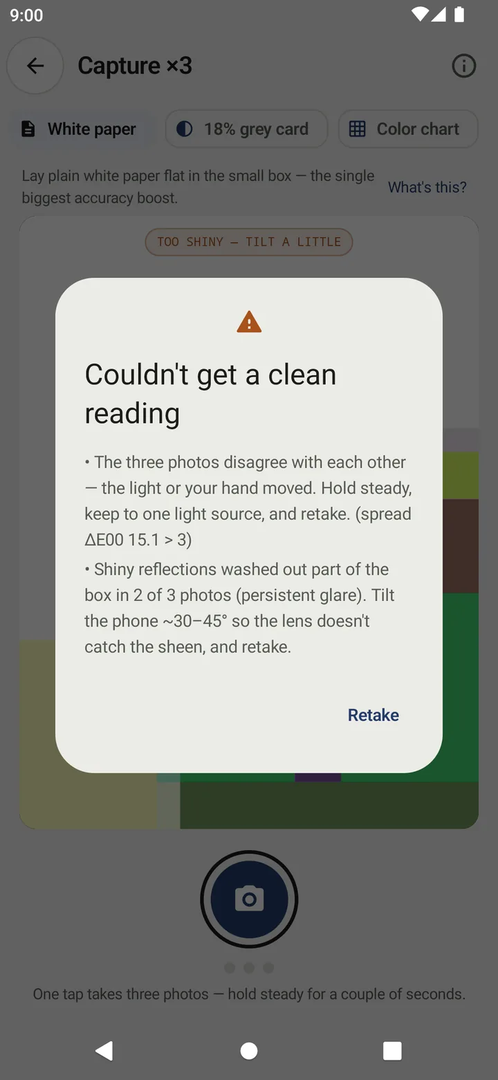 Couldn't get a clean reading dialog listing two reasons: the three photos disagree (spread ΔE00 15.1 > 3) and shiny reflections washed out part of the box in 2 of 3 photos, with a Retake button